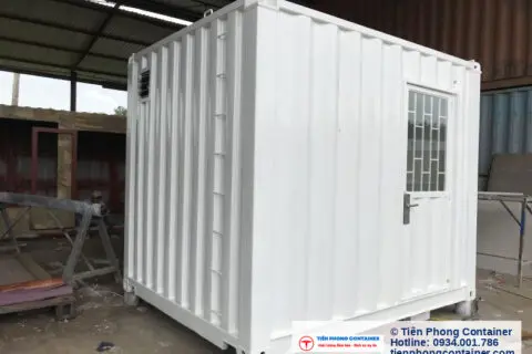 Container văn phòng màu trắng có cửa sổ và cửa ra vào, đặt tại xưởng đang hoàn thiện