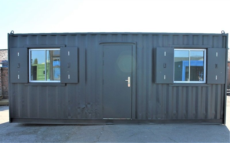 Container sơn xám đen có cửa đi và hai cửa sổ, dùng làm nhà mini hoặc phòng ở