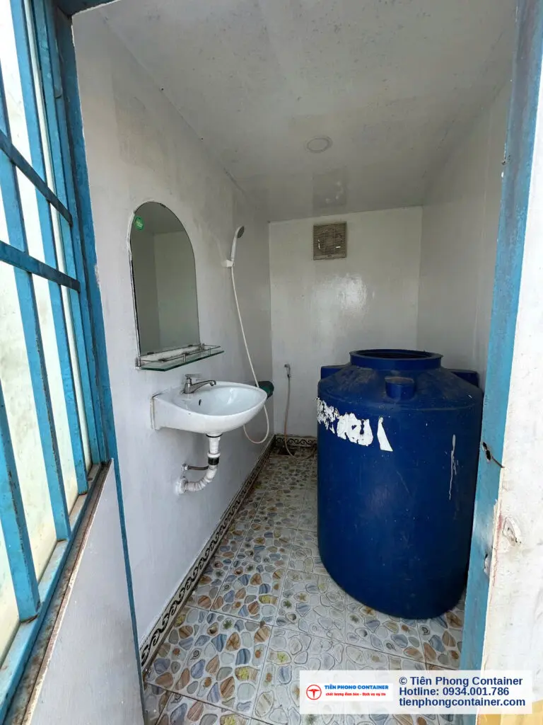 Bể chứa nước màu xanh đặt trong container vệ sinh 10ft cạnh lavabo tại Thủ Dầu Một