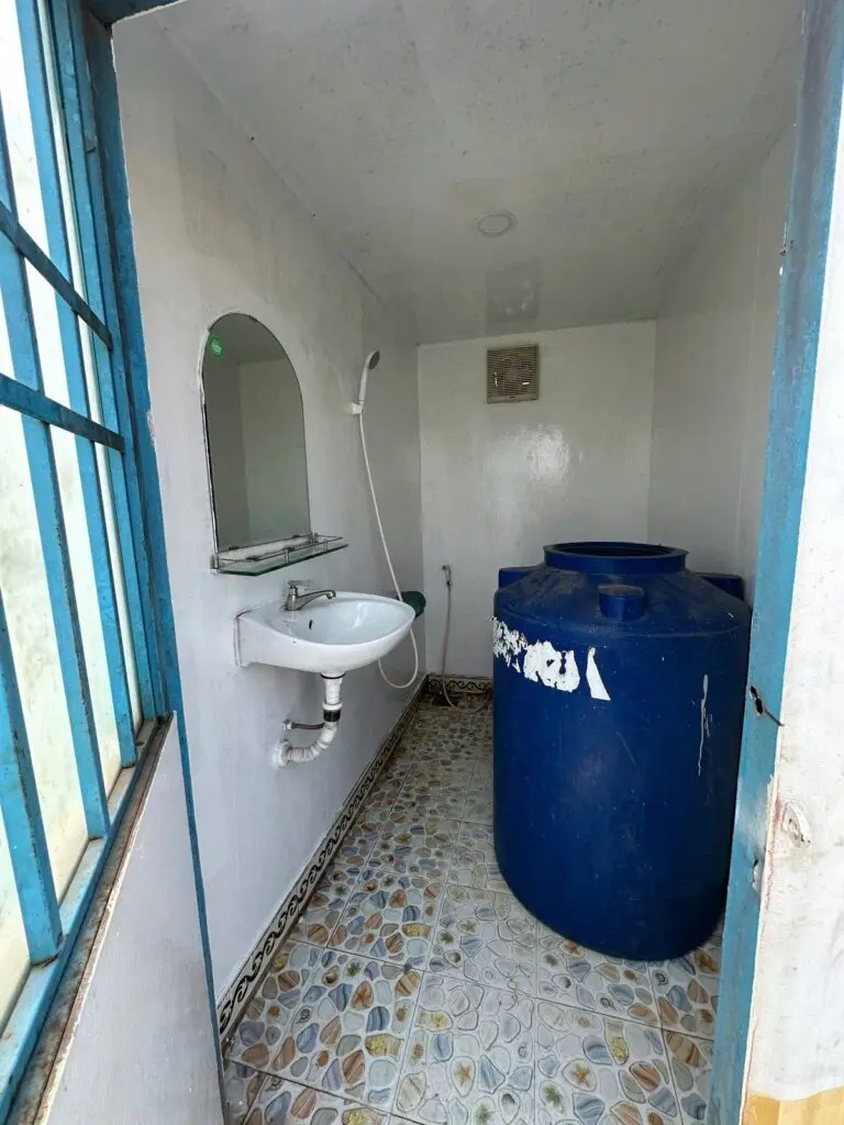 Bể chứa nước màu xanh đặt trong container vệ sinh 10ft cạnh lavabo tại Thủ Dầu Một