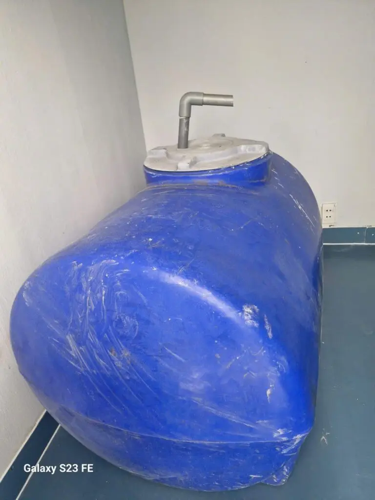 Bể chứa nước nằm ngang màu xanh trong buồng WC của container văn phòng 40ft tại cảng Long Bình