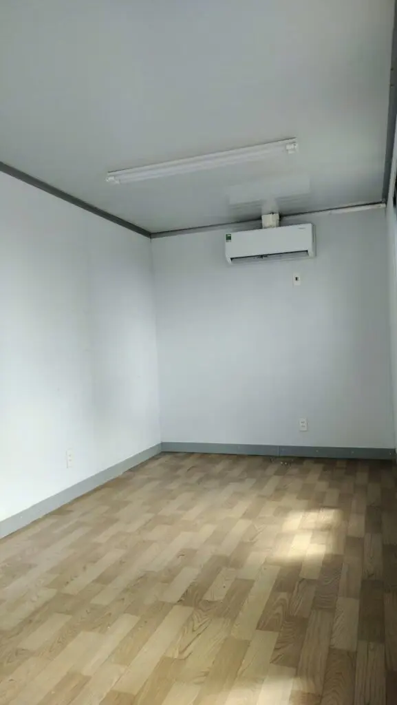 Bên trong container văn phòng 20ft sàn vinyl giả gỗ, vách trắng và máy lạnh treo tường tại KCN Long Hậu