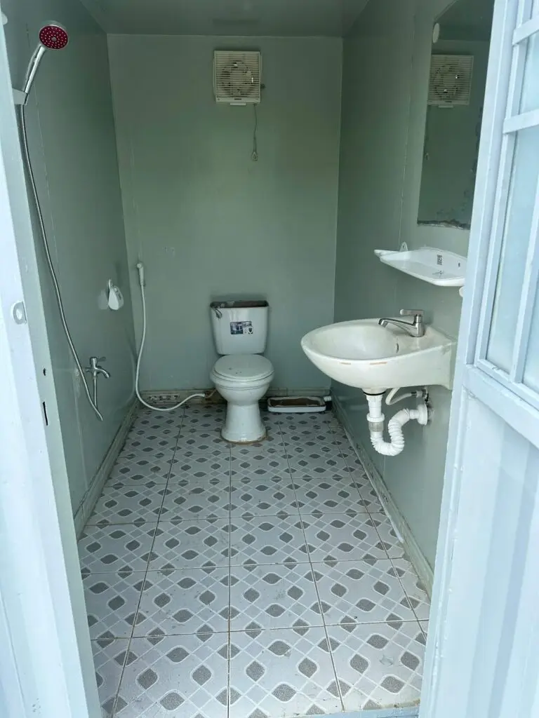 Buồng vệ sinh container 10ft có bồn cầu, lavabo, vòi sen và sàn gạch chống trơn tại Củ Chi