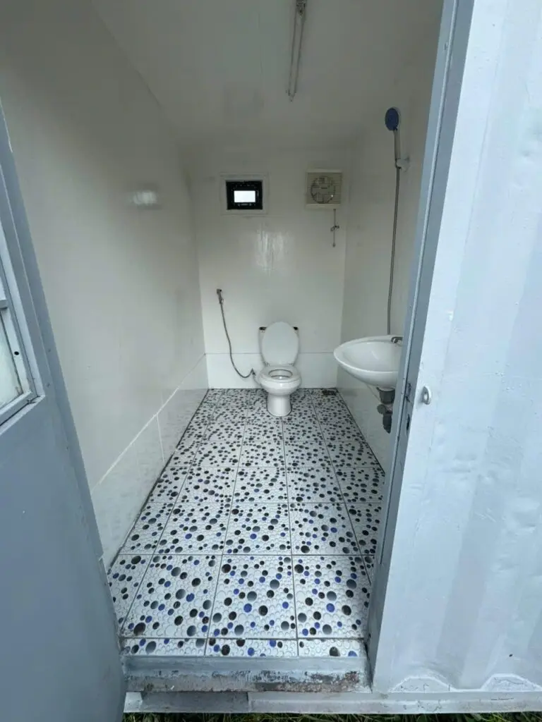 Buồng vệ sinh trong container 20ft có bồn cầu, lavabo và vòi sen, sàn gạch hoa văn tại Lâm Đồng