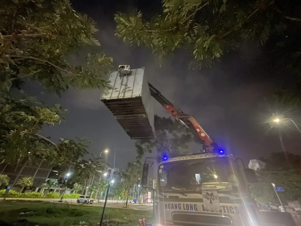 Cần cẩu xoay container văn phòng 20ft qua khu cây xanh tại Global City