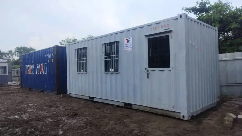 Container văn phòng 20ft cửa sổ khung bảo vệ đặt cạnh container xanh dương tại KCN Vĩnh Lộc