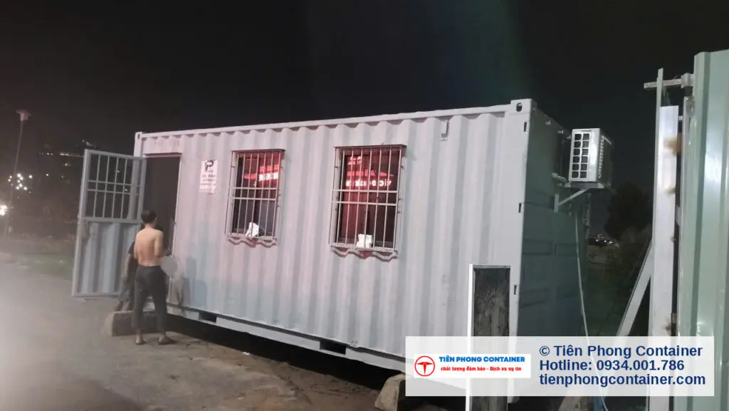 Container văn phòng 20ft lắp máy lạnh treo ngoài, nhân viên công trường đứng cạnh tại Quận 2