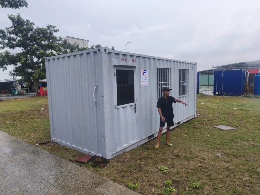 Container văn phòng 20ft sơn xám có cửa sổ khung bảo vệ trên bãi cỏ Global City