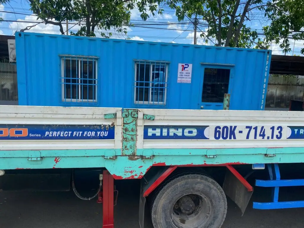 Container văn phòng 20ft sơn xanh dương cửa sổ khung bảo vệ trên xe tải chở tại Biên Hòa