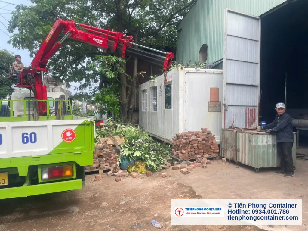 Container văn phòng 20ft vừa hạ xuống cạnh xe tải gắn cẩu và công nhân tại Thủ Đức
