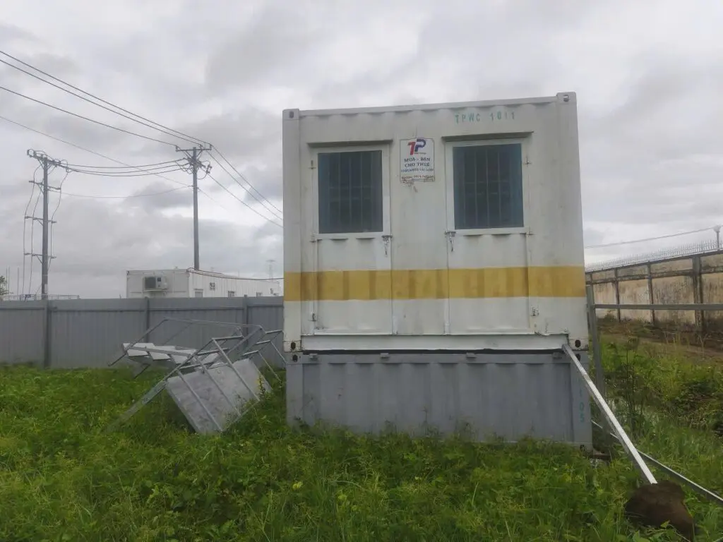 Container văn phòng 40ft sơn trắng vạch vàng đặt trên bãi cỏ cạnh hàng rào khu vực Cảng Thị Vải