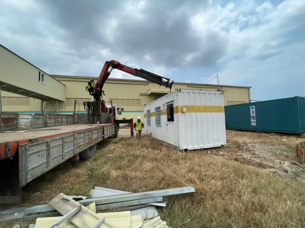 Container văn phòng sơn trắng vạch vàng đã đặt trên cỏ cạnh nhà xưởng KCN Phú Mỹ 1