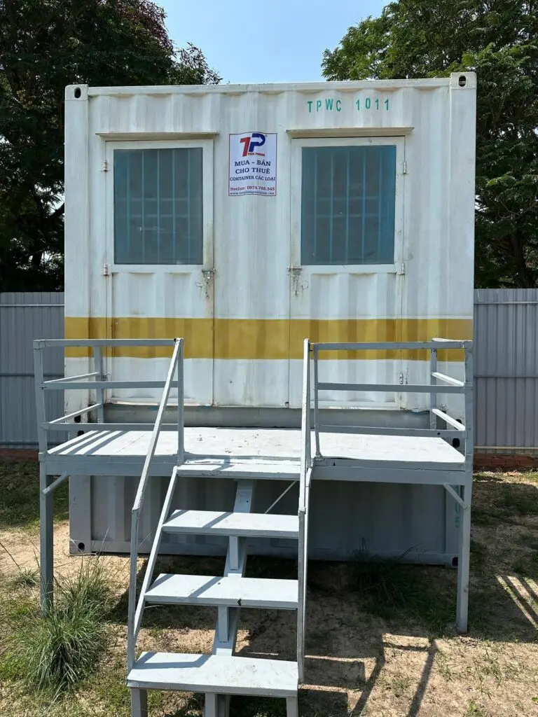 Container vệ sinh 10ft đặt chồng trên container nền, có sàn thao tác và cầu thang bộ kẻ băng vàng tại Thủ Dầu Một