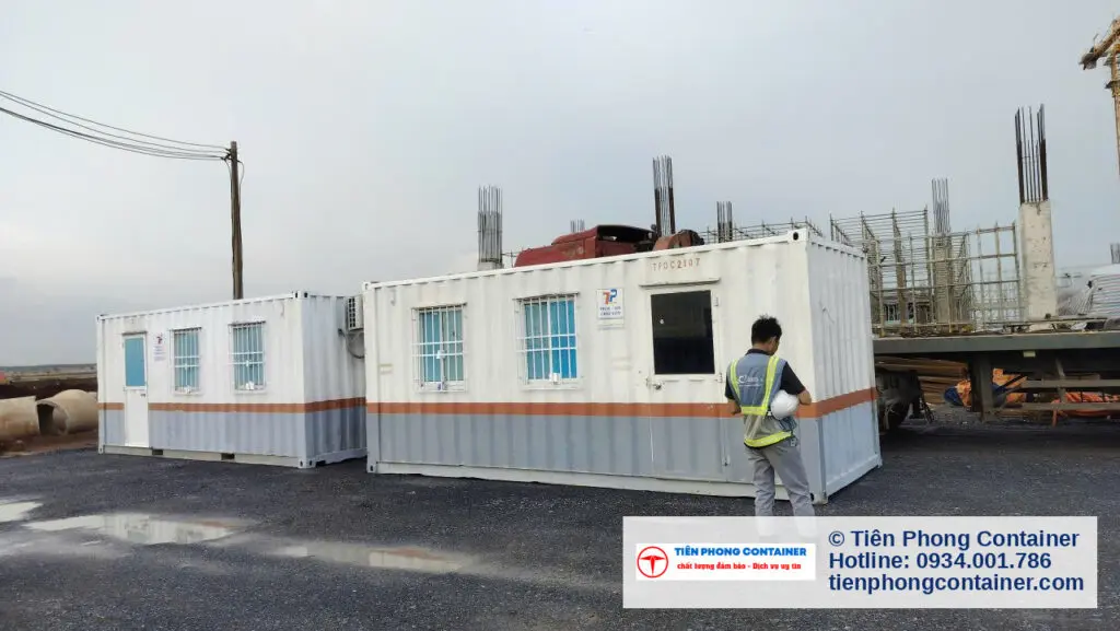 Hai container văn phòng 20ft sọc cam đặt cạnh nhau, nhân viên công trường đứng kiểm tra
