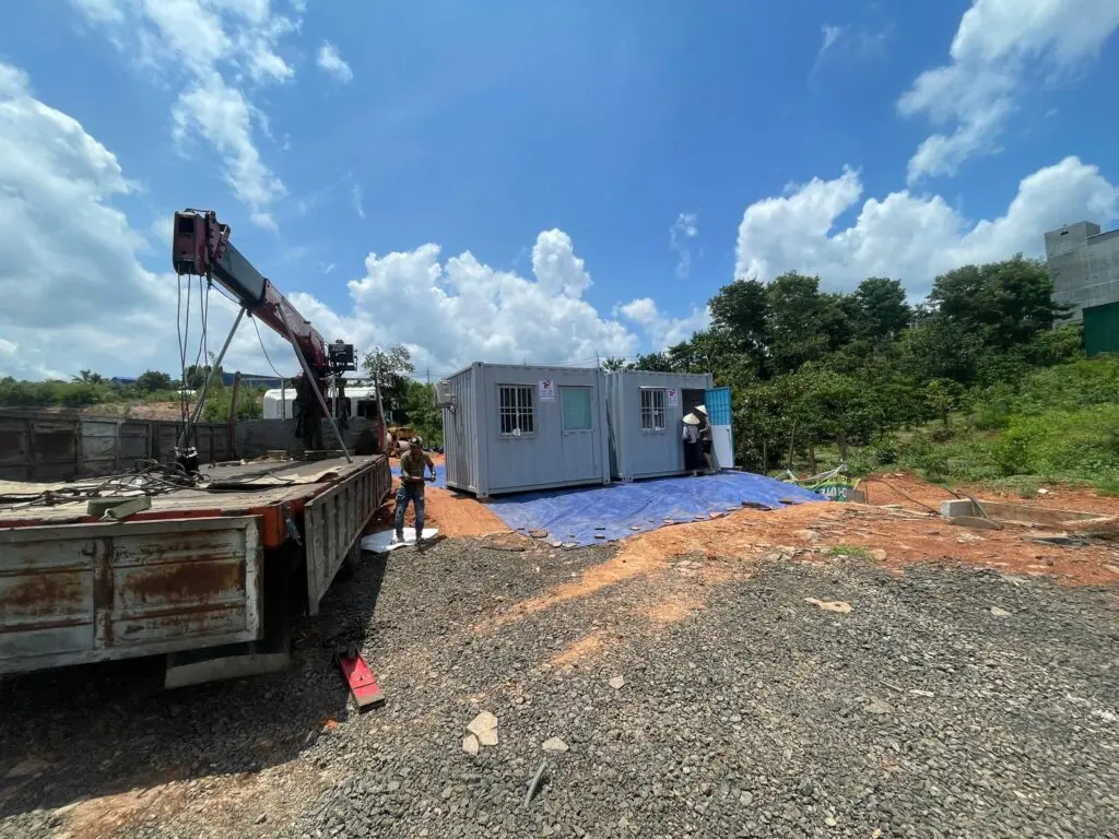 Xe cẩu hạ container văn phòng từ xe tải xuống mặt bằng tại Bình Phước