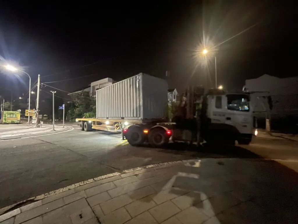 Xe đầu kéo chở container văn phòng 20ft vào khu vực Global City lúc đêm