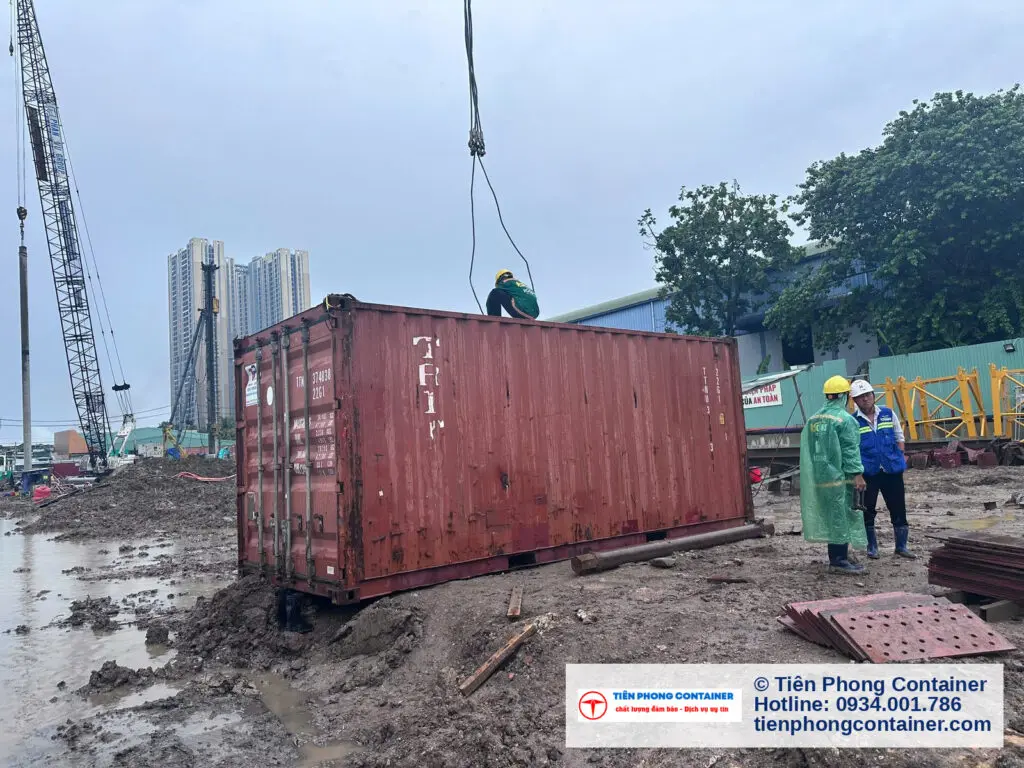 Xe tải gắn cẩu hạ container kho 20ft nâu đỏ xuống mặt bằng công trình tại Thuận An