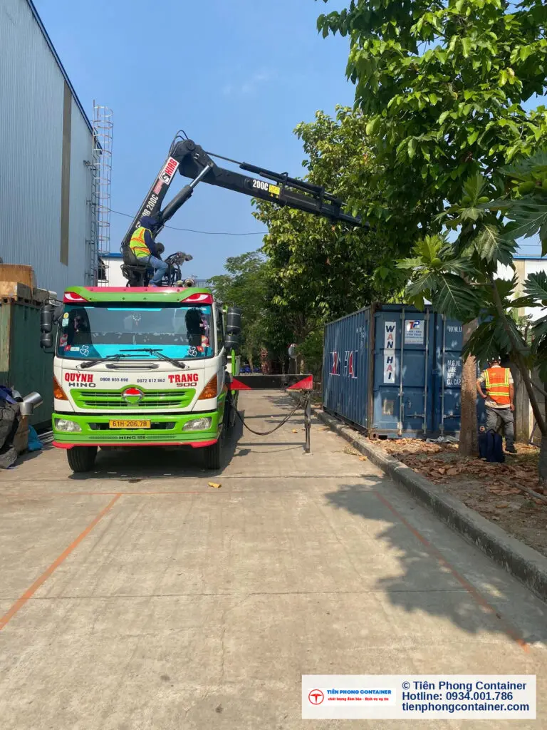 Xe tải gắn cẩu hạ container kho 20ft sơn xanh cạnh nhà xưởng tại KCN VSIP 2