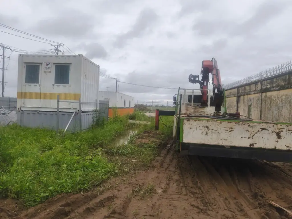 Xe tải gắn cẩu và container vệ sinh 10ft trắng trên đường đất tại Cần Thơ